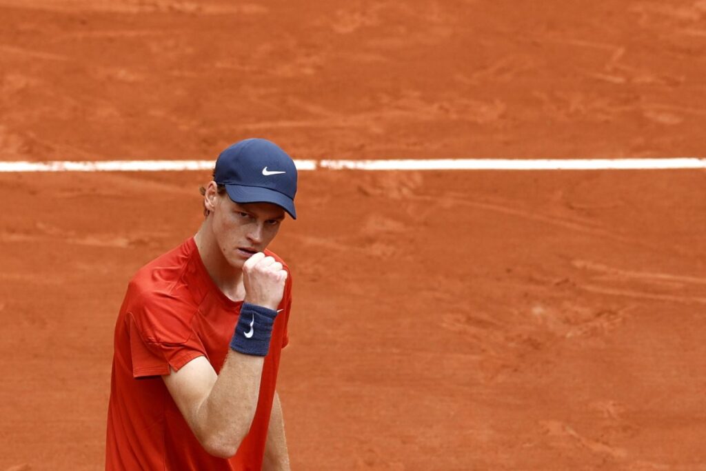Jannik Sinner esulta alzando un pugno dopo aver vinto un punto sulla terra rossa di Parigi