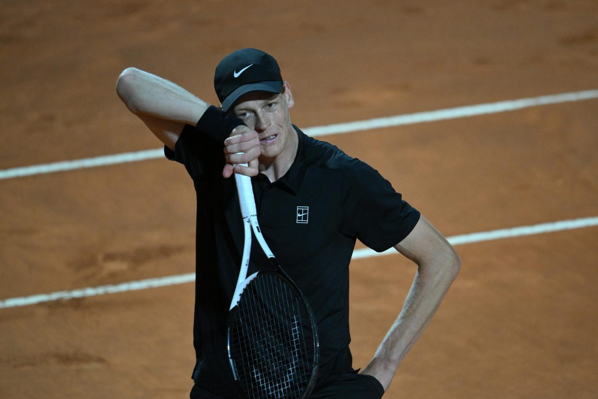Jannik Sinner in campo che si asciuga il sudore con il polsino