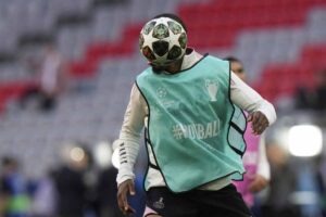 Un calciatore del PSG col volto nascosto dal pallone della finale
