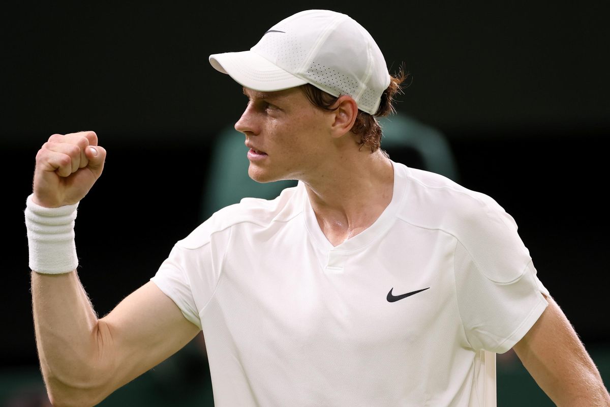 Jannik Sinner, vestito di bianco, esulta dopo una vittoria a Wimbledon