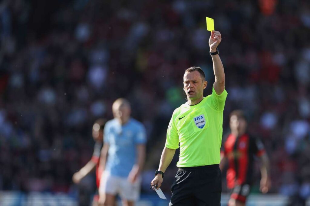 Stuart Attwell ammonisce un calciatore