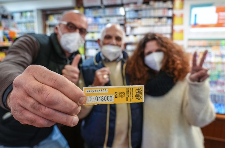 Un uomo mostra un biglietto della lotteria